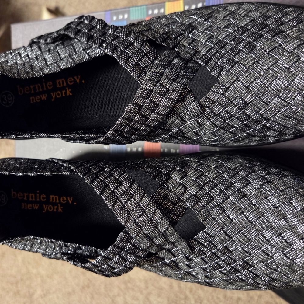 The CLEOPATRA BY Bernie Mev. Metallic Woven Slip-On Flats in Silver and Black